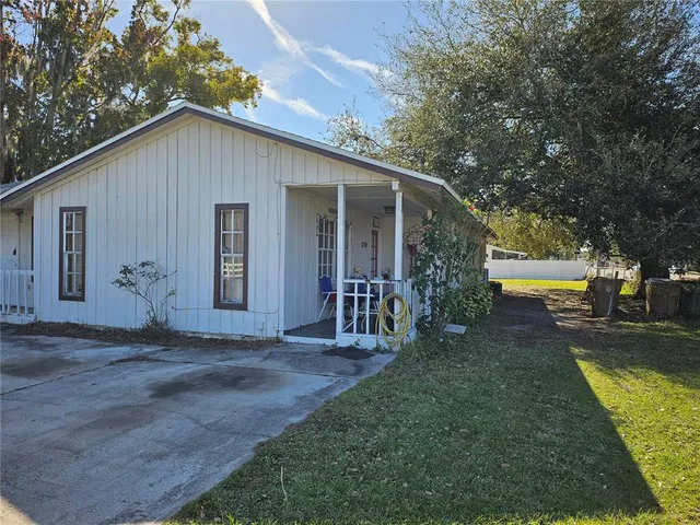 a view of a house with backyard and trees