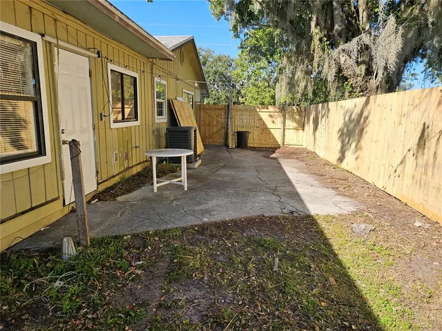 a view of a house with backyard and tree
