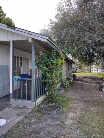 a view of a house with a yard and tree