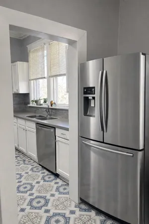 a kitchen with granite countertop a refrigerator and a sink