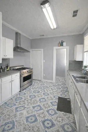 a kitchen with granite countertop a stove a sink and a refrigerator