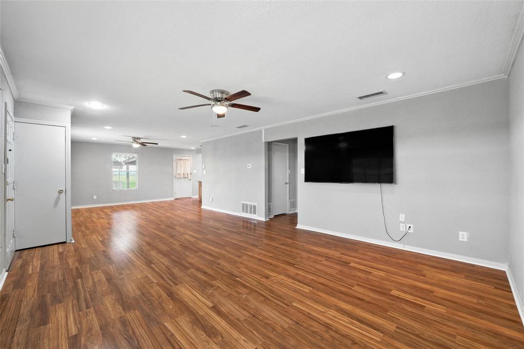 358 Wright Road Waxahachie, TX 75167 - Photo 16 of 38 a view of an empty room with wooden floor and a kitchen