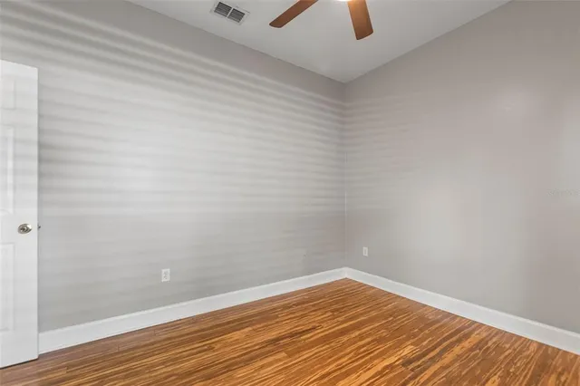 a view of an empty room with wooden floor