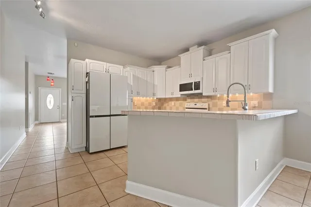 a kitchen with stainless steel appliances granite countertop a refrigerator and a stove top oven