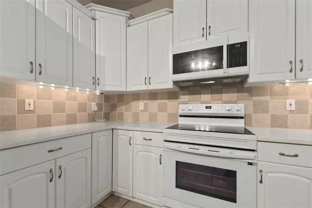 a kitchen with white cabinets stainless steel appliances and sink