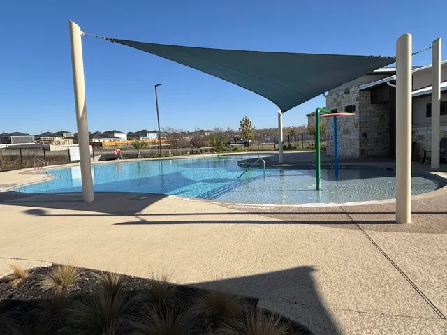 a view of a swimming pool and a back yard