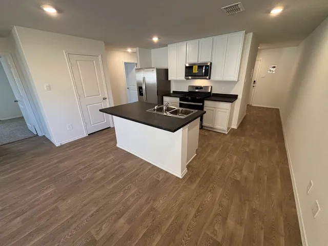 a kitchen with stainless steel appliances a white stove top oven and a refrigerator