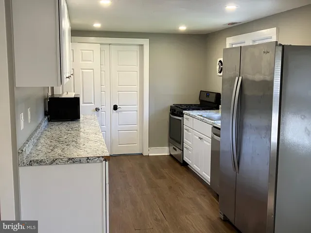 a kitchen with stainless steel appliances granite countertop a refrigerator and a sink