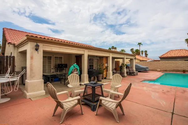 a view of a patio with table and chairs near an umbrella