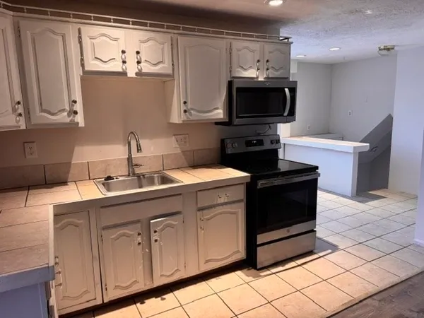 a kitchen with stainless steel appliances a sink stove and cabinets