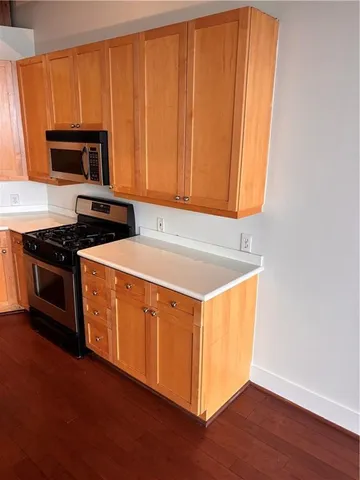 a kitchen with stainless steel appliances granite countertop a stove a sink and a microwave