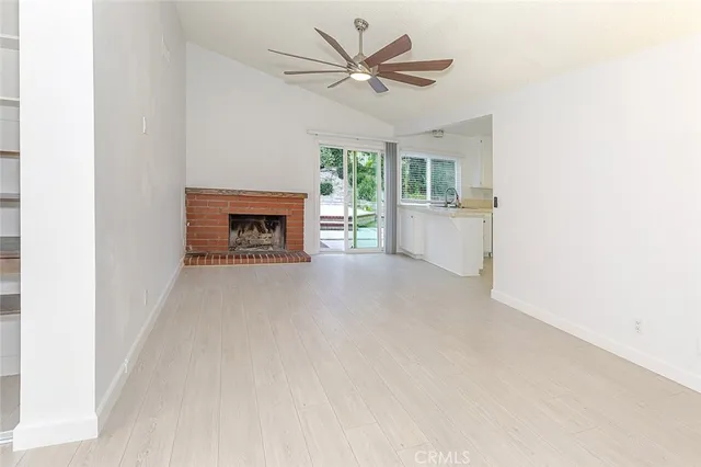 a view of a livingroom with a fireplace and window