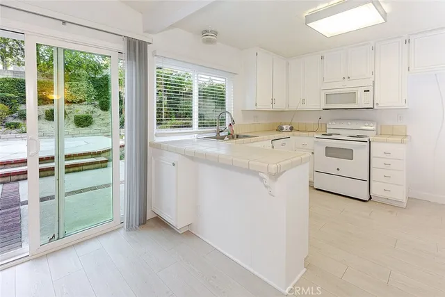 a kitchen with cabinets appliances a sink and a window