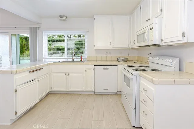 a kitchen with white cabinets and white appliances
