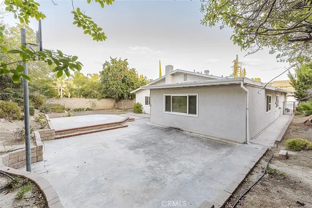 a view of a house with a backyard and a tree