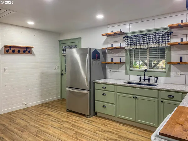 a kitchen with stainless steel appliances granite countertop a refrigerator and a sink