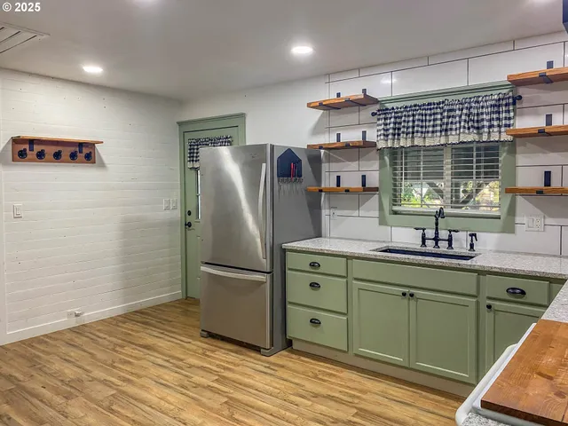a kitchen with stainless steel appliances granite countertop a refrigerator and a sink