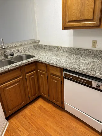 a kitchen with granite countertop wood cabinets and a sink
