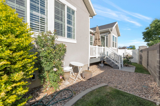 2319 North 3370 West Lehi, UT 84048 - Photo 30 of 30 Rear exterior featuring a wooden deck with white railing and steps, a gravel patio area, and a section of manicured lawn