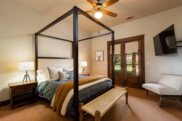 a bedroom with a bed window and a flat screen tv