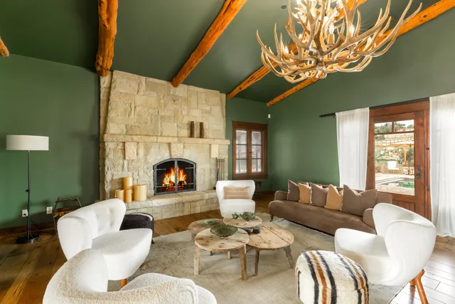 a living room with furniture a fireplace and a large window