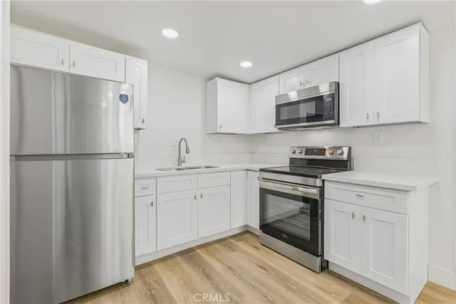 a kitchen with stainless steel appliances granite countertop a refrigerator stove a sink and a microwave