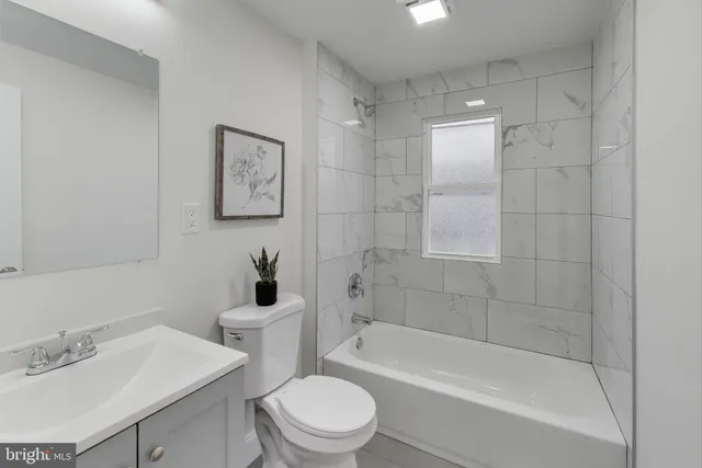 a bathroom with a bathtub shower sink mirror vanity and toilet