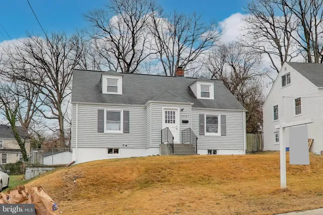 a front view of a house with a yard covered in snow