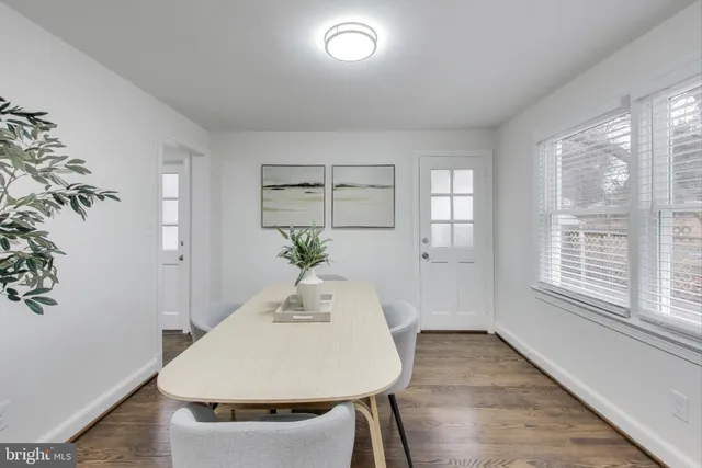 a dining room with wooden floor and windows