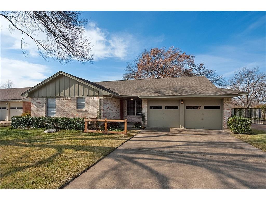 Single story home featuring board and batten siding, an attached garage, driveway, and a front lawn