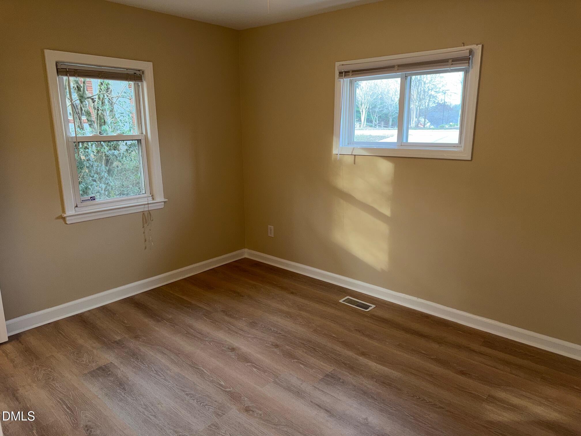 3117 Tryon Road Raleigh, NC 27603 - Photo 11 of 21 an empty room with wooden floor and windows