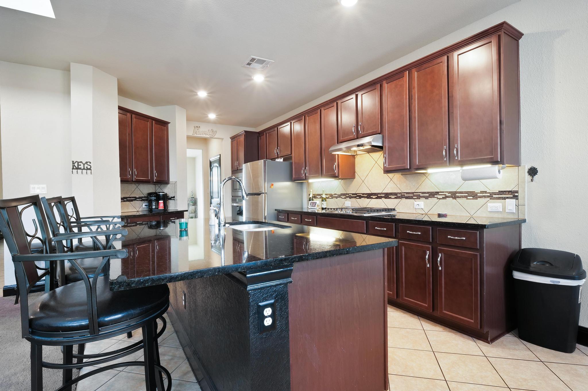 205 Windom Way Georgetown, TX 78626 - Photo 6 of 28 a kitchen with granite countertop a stove a sink and a microwave