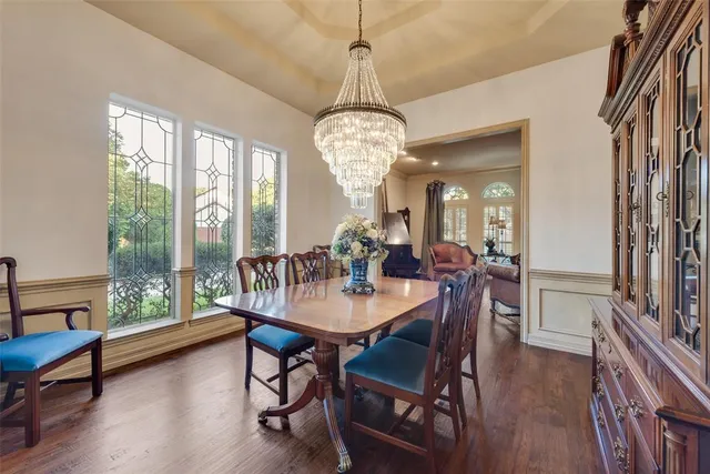 a dining room with furniture a chandelier and wooden floor