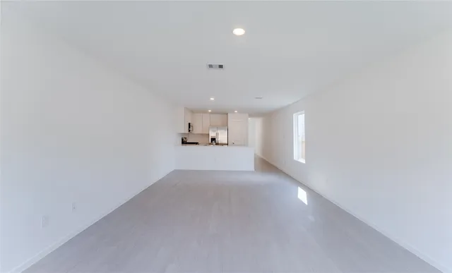 a view of a big room with wooden floor and windows