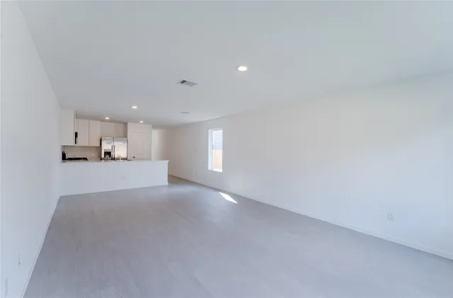 a view of empty room with kitchen