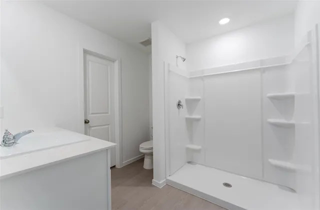 a bathroom with a shower a toilet and sink