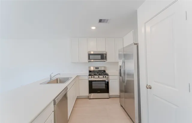 a kitchen with stainless steel appliances granite countertop a refrigerator and a stove