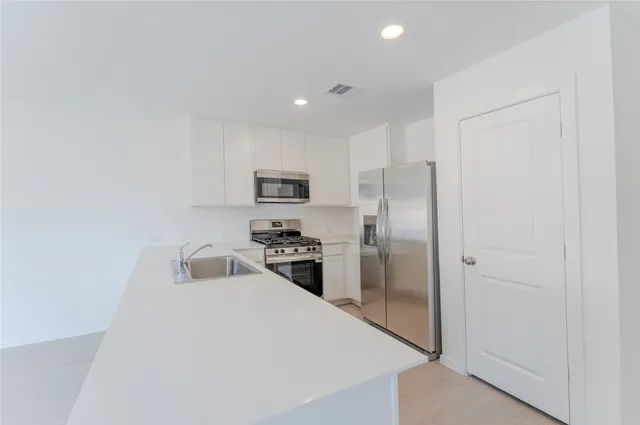 a kitchen with stainless steel appliances a refrigerator stove microwave and sink