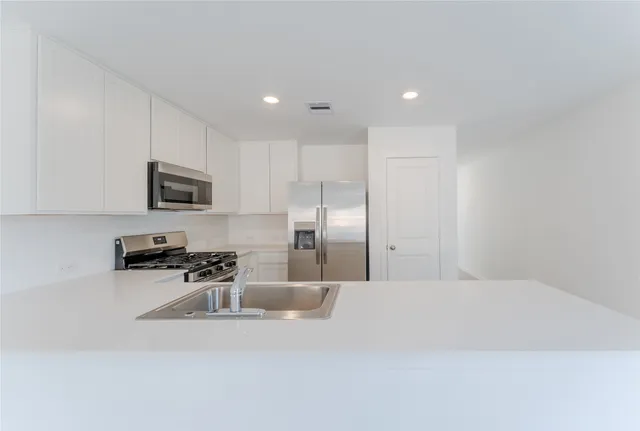 a kitchen with stainless steel appliances a refrigerator a stove a microwave and cabinets