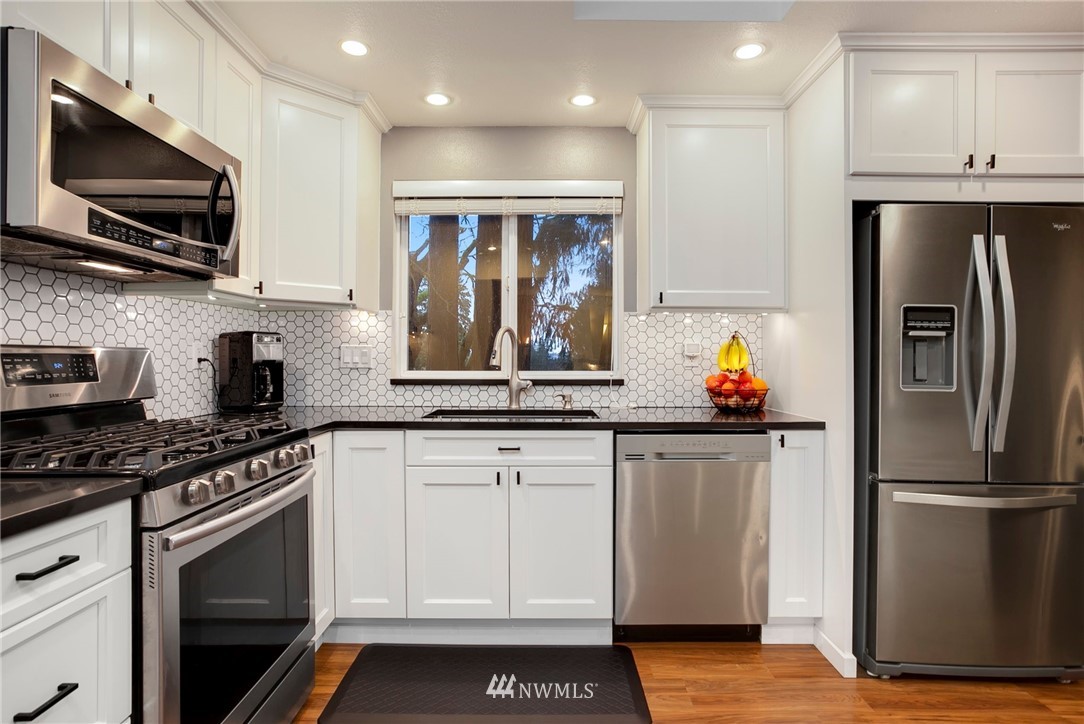 10727 126th Avenue Northeast Kirkland, WA 98033 - Photo 11 of 40 a kitchen with stainless steel appliances granite countertop a refrigerator sink and microwave