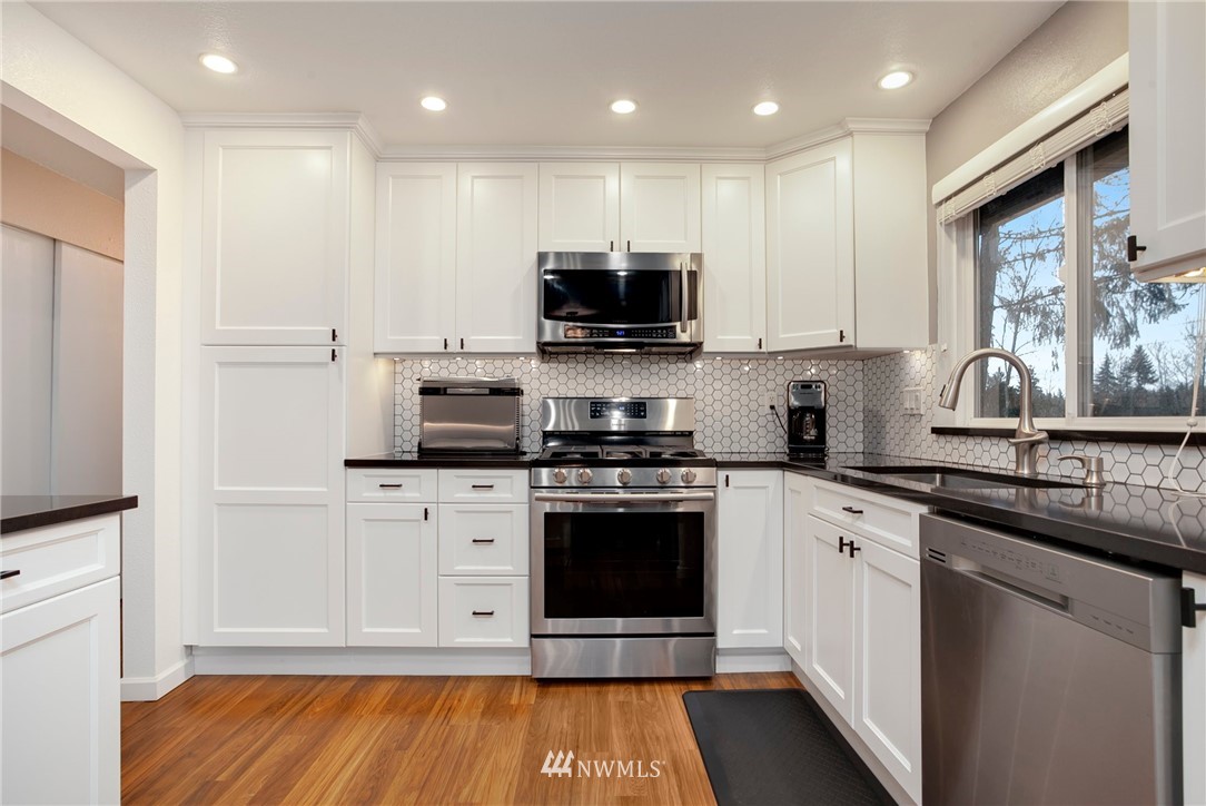 10727 126th Avenue Northeast Kirkland, WA 98033 - Photo 13 of 40 a kitchen with stainless steel appliances granite countertop a stove a sink and a microwave