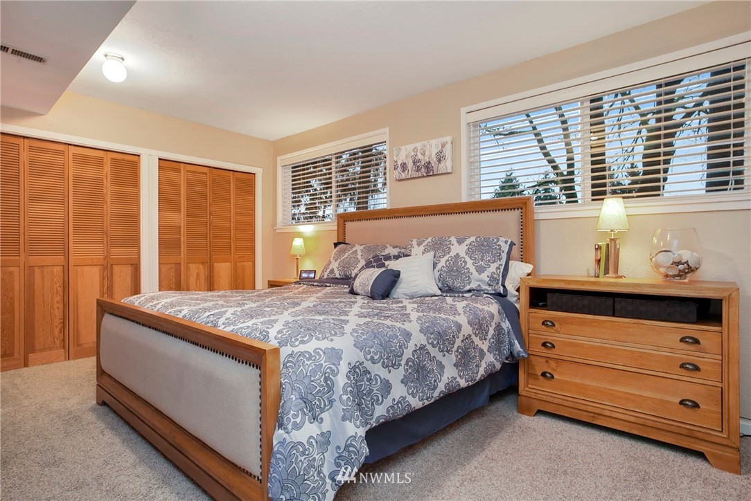 10727 126th Avenue Northeast Kirkland, WA 98033 - Photo 14 of 40 a bed sitting in a bedroom next to a window