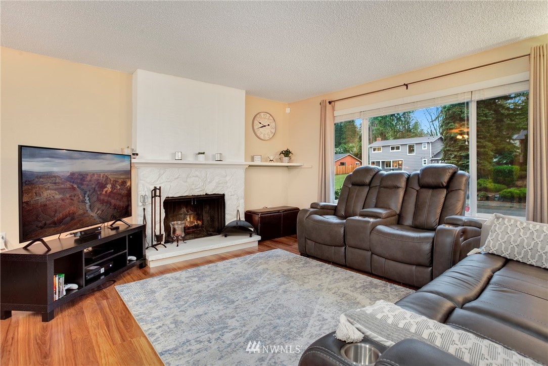 10727 126th Avenue Northeast Kirkland, WA 98033 - Photo 3 of 40 a living room with furniture a flat screen tv and a fireplace