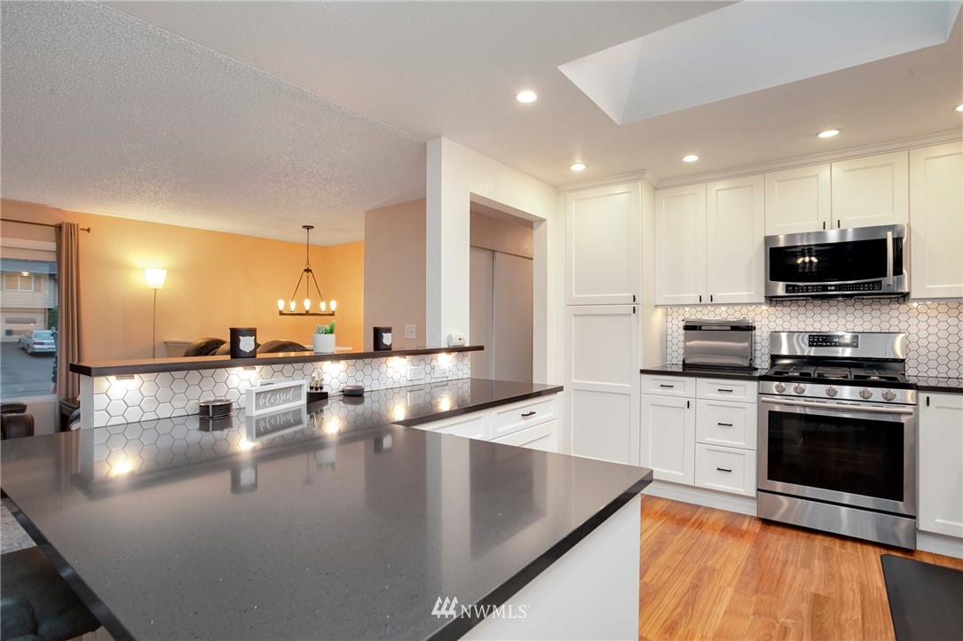 10727 126th Avenue Northeast Kirkland, WA 98033 - Photo 8 of 40 a kitchen with stainless steel appliances granite countertop a sink counter space and cabinets