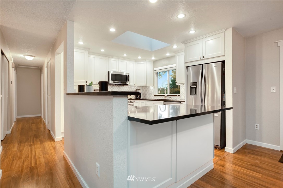 10727 126th Avenue Northeast Kirkland, WA 98033 - Photo 9 of 40 a kitchen with stainless steel appliances a refrigerator sink and microwave