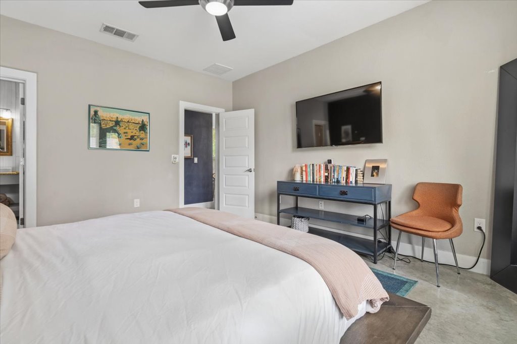 1800 Webberville Road, Unit B Austin, TX 78721 - Photo 15 of 30 Spacious room featuring neutral painted walls, a ceiling fan with integrated lighting, and a wall-mounted television