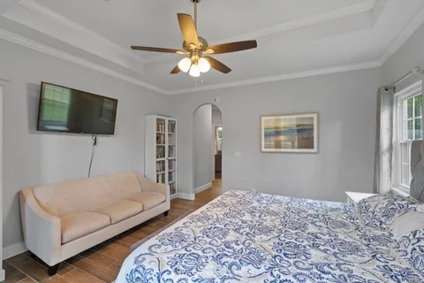 a bedroom with a bed couch and a flat screen tv