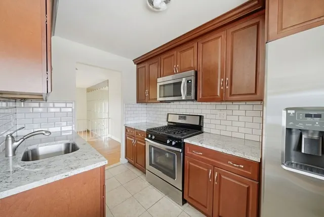 a kitchen with granite countertop a sink stove and cabinets