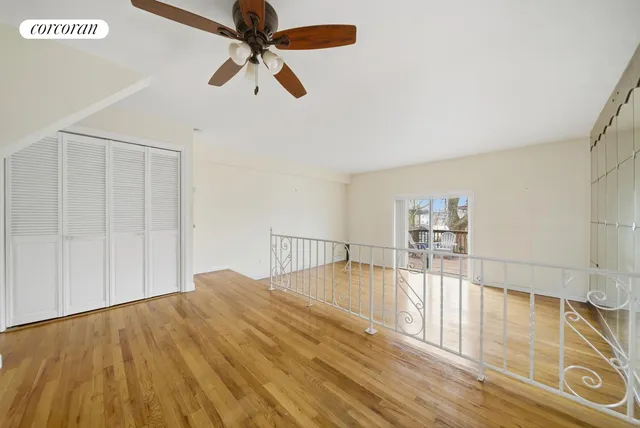 a view of empty room with wooden floor