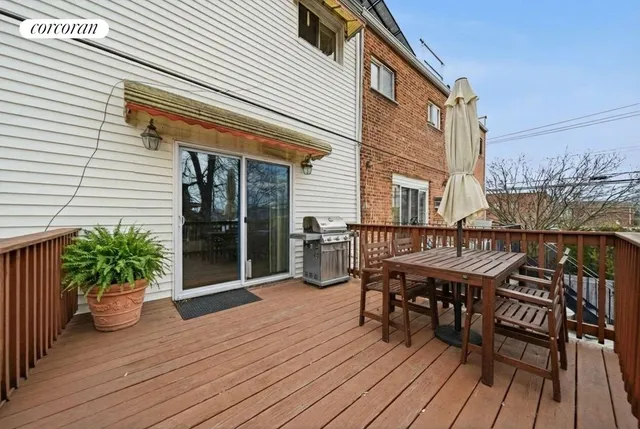 a balcony with wooden floor table and chairs